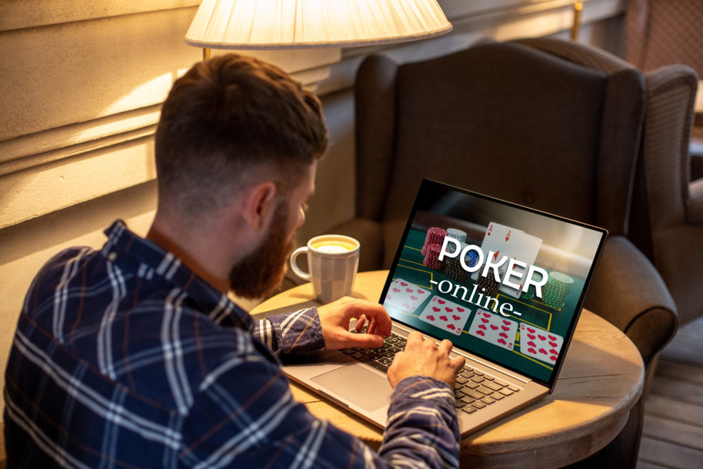 Mand sidder og læser de seneste poker nyheder online